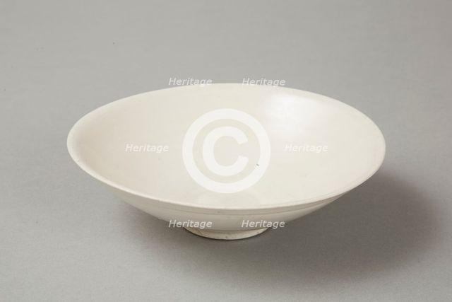 A shallow cream glazed bowl with rolled rim andraised footrim, Tang dynasty, c.800-900. Creator: Unknown.