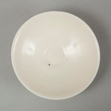 A shallow cream glazed bowl with rolled rim andraised footrim, Tang dynasty, c.800-900. Creator: Unknown