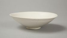 A shallow cream glazed bowl with rolled rim andraised footrim, Tang dynasty, c.800-900