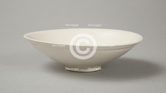A shallow cream glazed bowl with rolled rim andraised footrim, Tang dynasty, c.800-900. Artist: Unknown.