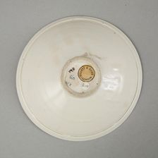 A shallow cream glazed bowl with rolled rim andraised footrim, Tang dynasty, c.800-900