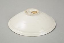 A shallow cream glazed bowl with rolled rim andraised footrim, Tang dynasty, c.800-900