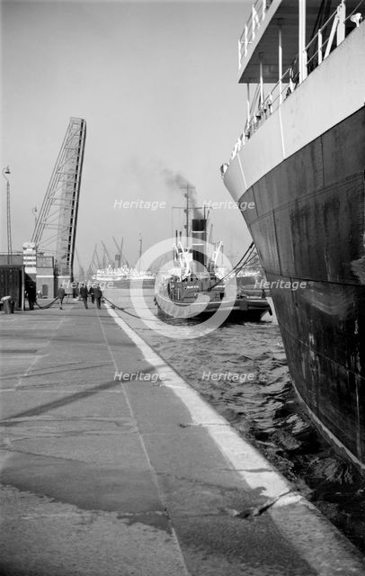 A ship being towed into the King George V Dock, Canning Town, London, c1945-c1965.  Artist: SW Rawlings