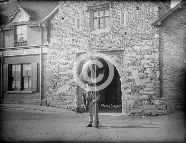 A shrimper with his equipment standing in front of Old Fishers Gate, Sandwich, Kent, c1860-c1922. Artist: Henry Taunt