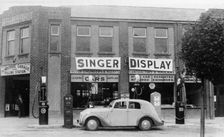 A Singer 11hp Airstream saloon car outside a Welsh garage, Wales, 1935