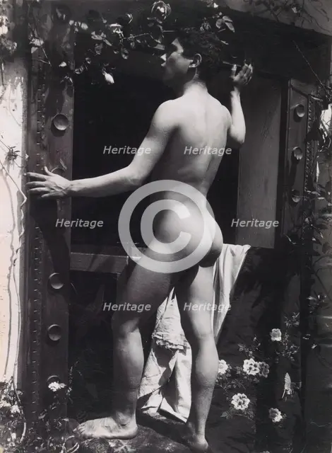 A Sicilian male, posing naked outdoors, by a doorway, c1900. Creator: Guglielmo Pluschow.