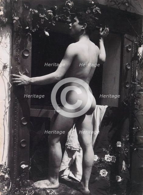 A Sicilian male, posing naked outdoors, by a doorway, c1900. Creator: Guglielmo Pluschow.