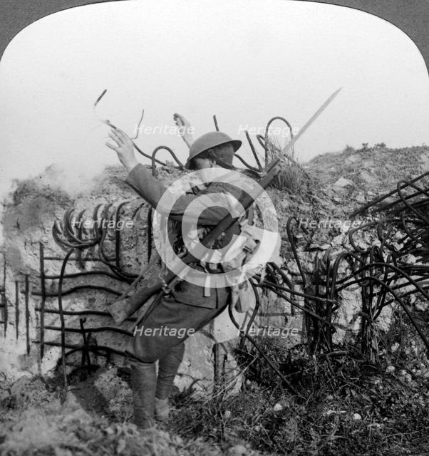 A soldier triggers a booby trap, World War I, 1914-1918.Artist: Realistic Travels Publishers