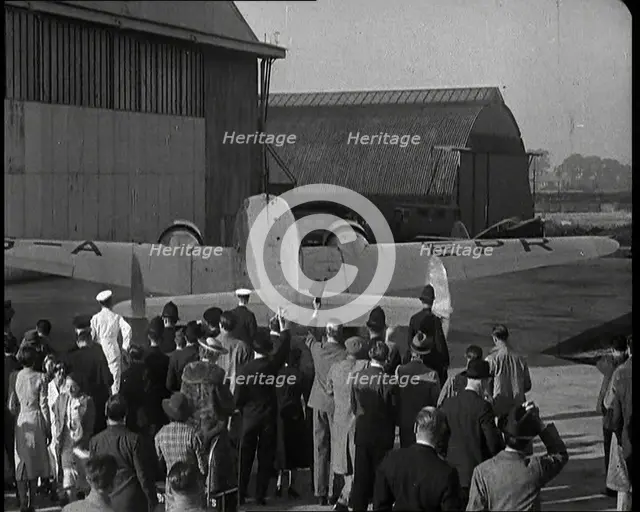 A Small Crowd at Heston Aerodrome Cheering the Moving Lockheed Aeroplane Carrying the..., 1938. Creator: British Pathe Ltd.