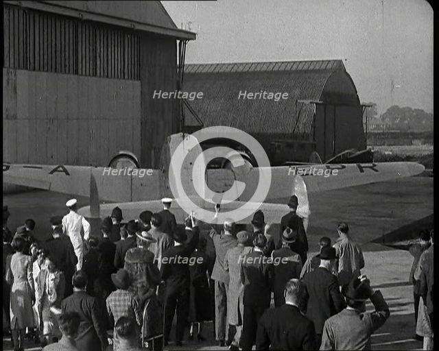 A Small Crowd at Heston Aerodrome Cheering the Moving Lockheed Aeroplane Carrying the..., 1938. Creator: British Pathe Ltd.