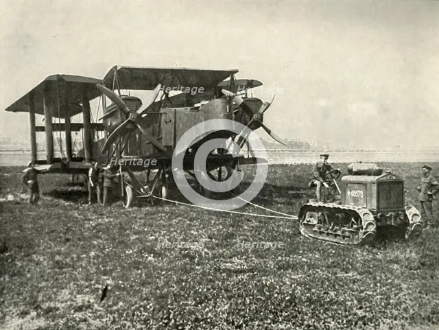 'A Small Motor Tractor Getting a Huge R.A.F. Bombing Machine into Position...', (1919).  Creator: Unknown.