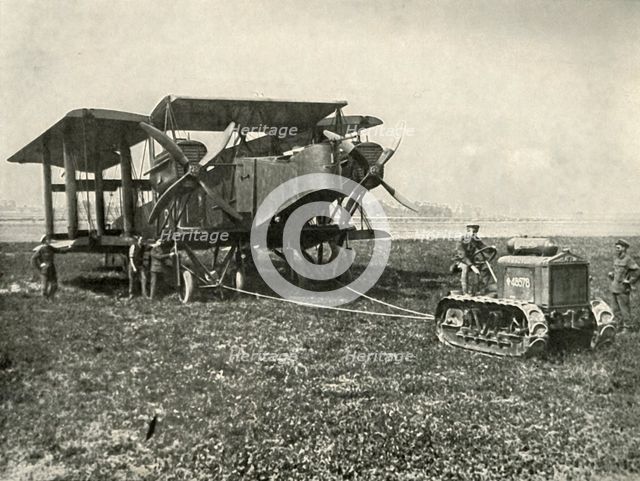 'A Small Motor Tractor Getting a Huge R.A.F. Bombing Machine into Position...', (1919).  Creator: Unknown.