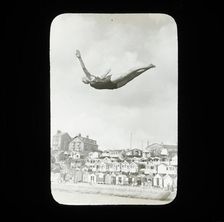 A swimmer diving into the sea at Southcliff, Walton-on-the-Naze, with beach huts on South..., 1920s. Creator: Norman Kingsley Harrison