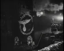 A Steam Train Decorated With Nazi Insignia on the Front Pulls Into a Station at Night, 1937. Creator: British Pathe Ltd