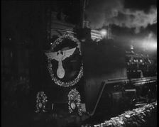A Steam Train Decorated With Nazi Insignia on the Front Pulls Into a Station at Night, 1937. Creator: British Pathe Ltd
