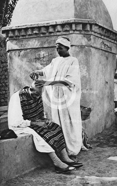 A street barber and his client, Algeria, Africa, 1922.Artist: Donald McLeish