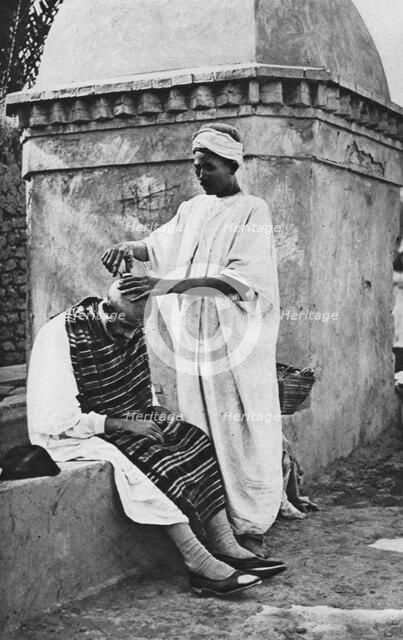 A street barber and his client, Algeria, Africa, 1922.Artist: Donald McLeish