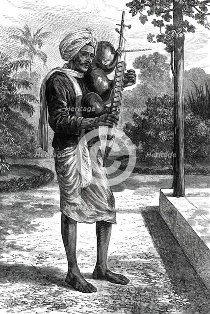 A strolling minstrel at Madras playing the tingadee, 1876. Creator: Unknown.