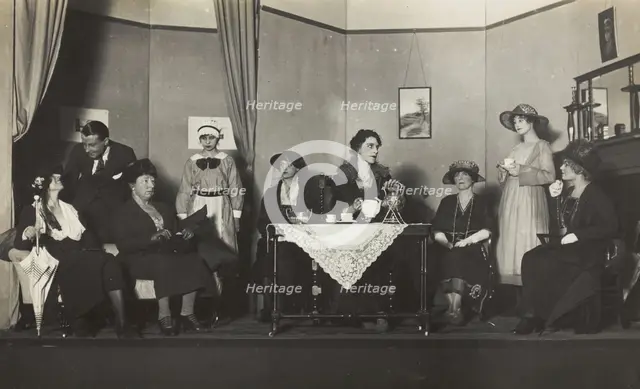 Amateur actors, some in drag, are having tea on stage, [between 1920 and 1929?]. Creator: Unknown.