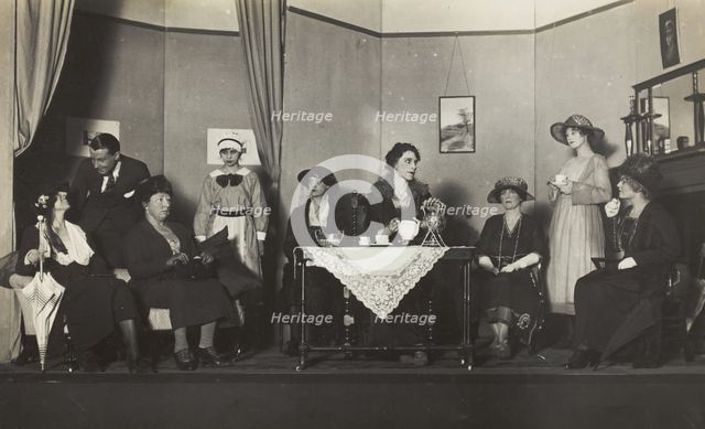 Amateur actors, some in drag, are having tea on stage, [between 1920 and 1929?]. Creator: Unknown.