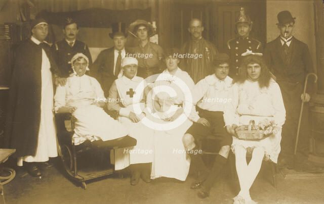 Amateur actors, some in drag, pose for a group portrait, (between 1910 and 1919?). Creator: Unknown.