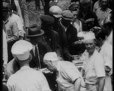 American Civilians Serving Meals for a Large Crowd on a Queue Outdoors, 1930. Creator: British Pathe Ltd