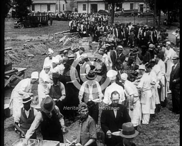 American Civilians Serving Meals for a Large Crowd on a Queue Outdoors, 1930. Creator: British Pathe Ltd.