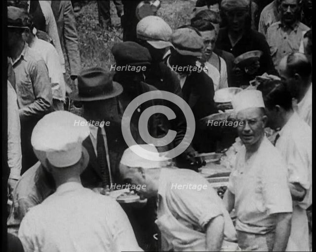 American Civilians Serving Meals for a Large Crowd on a Queue Outdoors, 1930. Creator: British Pathe Ltd.