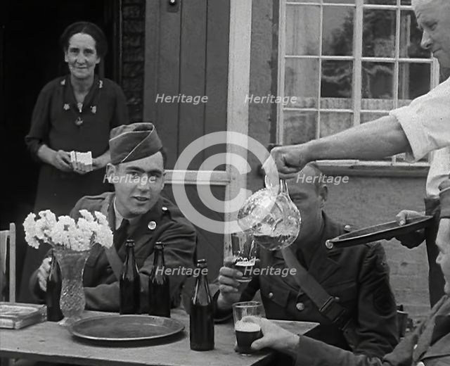 American Airmen Drinking Outside a Public House in England, and Being Served by..., 1943-1944. Creator: British Pathe Ltd.