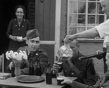American Airmen Drinking Outside a Public House in England, and Being Served by..., 1943-1944. Creator: British Pathe Ltd