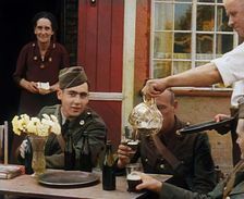 American Airmen Drinking Outside a Public House in England, and Being Served by..., 1943-1944. Creator: British Pathe Ltd
