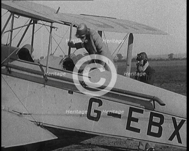 American Aviator Amelia Mary Earhart Wearing a Helmet Boarding an Airplane, 1920. Creator: British Pathe Ltd.