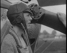 American Aviator Amelia Mary Earhart Wearing a Helmet in Front of an Airplane, 1920. Creator: British Pathe Ltd