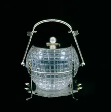 American glass biscuit barrel cut in the shape of a mesh patterned golf ball, 1910. Creator: Unknown