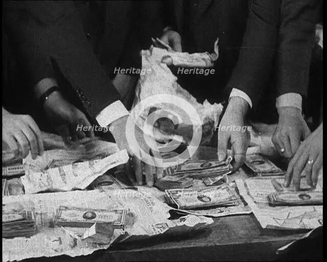 American Police Officers Counting Money Found in Relation To the Lindbergh's Kidnapping Case, 1930s. Creator: British Pathe Ltd.