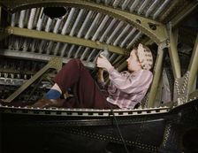 An A-20 bomber being riveted by a woman...Douglas Aircraft Company plant at Long Beach, Calif., 1942 Creator: Alfred T Palmer