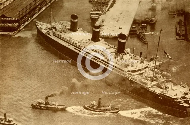 'An Aerial Photograph of the "Leviathan" Being Towed By Small Tugs Into Her Dock At New York', c1930 Creator: Unknown.