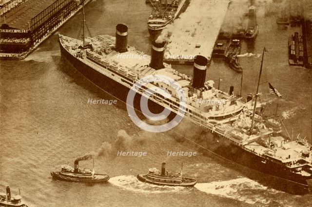 'An Aerial Photograph of the "Leviathan" Being Towed By Small Tugs Into Her Dock At New York', c1930 Creator: Unknown.