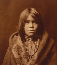 An Apache girl, head-and-shoulders portrait, facing front, wearing bead necklace..., c1903. Creator: Edward Sheriff Curtis
