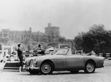 An Aston Martin DB2-4 MKII, with Windsor Castle in the background, 1956