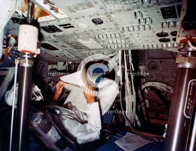An astronaut inside a NASA Command Module, 1970s.Artist: NASA