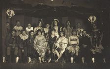 An ensemble cast of British soldiers, some in drag, pose on stage, 1919. Creator: Unknown