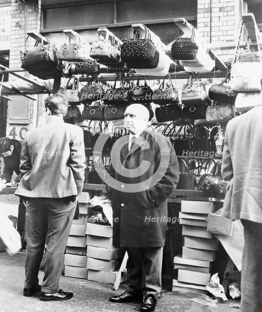 An East End market stall selling handbags, London. Creator: Unknown.