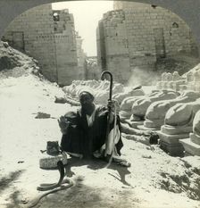 An Egyptian Snake Charmer Piles His Trade Beside the Avenue of Sphinxes, Temple of Karnak, Thebes, Creator: Unknown