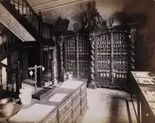 An eighteenth-century apothecary's shop with intricately carved wooden showcases; recreated.... Creator: Unknown