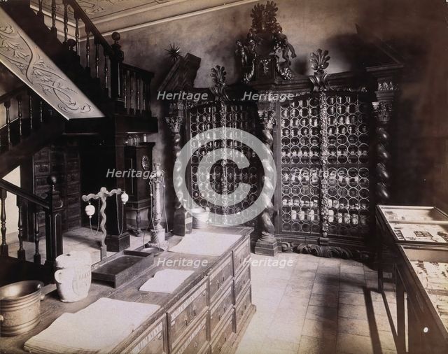 An eighteenth-century apothecary's shop with intricately carved wooden showcases; recreated.... Creator: Unknown.