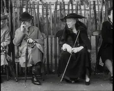 An Elderly Woman Wearing a Wide Hat, a Fur Stole, and Holding a Walking Stick Sitting on a..., 1938. Creator: British Pathe Ltd