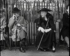 An Elderly Woman Wearing a Wide Hat, a Fur Stole, and Holding a Walking Stick Sitting on a..., 1938. Creator: British Pathe Ltd
