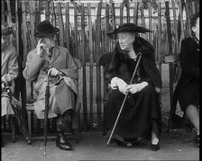 An Elderly Woman Wearing a Wide Hat, a Fur Stole, and Holding a Walking Stick Sitting on a..., 1938. Creator: British Pathe Ltd