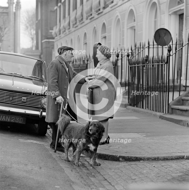 An elderly man chats to an elderly woman on the pavement, London, c1946-c1959. Artist: John Gay